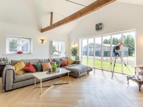 a living room with a couch and a camera at Granary Barn in Ashwellthorpe