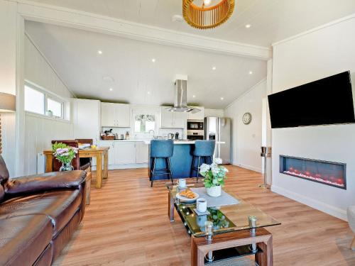 a living room with a couch and a table at Glencoe Luxury Lodge in Erskine