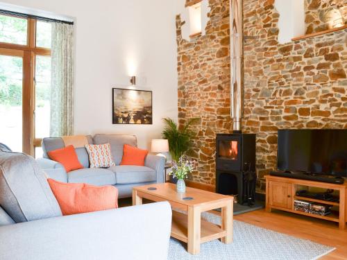 a living room with a couch and a fireplace at The Horse Gin - Uk11024 in East Worlington