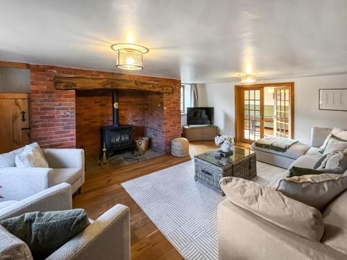 a living room with two couches and a fireplace at Pant Ifan Goch in St Asaph