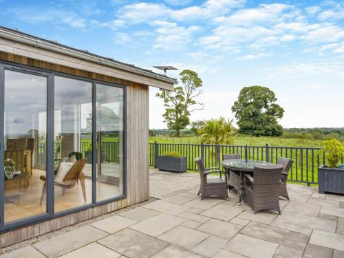 a patio with a table and chairs and a fence at Whitehill Lodge - Uk47194 in Kirkcambeck
