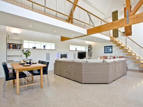 a dining room and living room with a couch and a table at Antells Farm Barn in Sturminster Newton