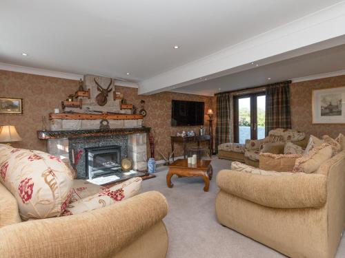 a large living room with couches and a fireplace at Hillend Farm House in Dalry