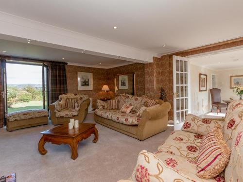 a large living room with couches and a table at Hillend Farm House in Dalry