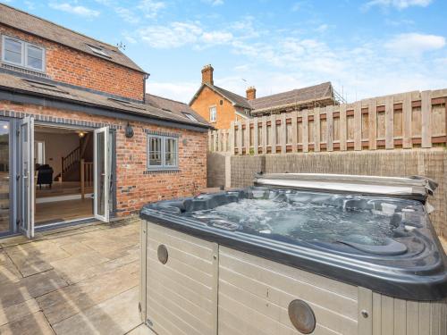 a hot tub on the patio of a house at Y Stabl - Uk12742 in Acrefair