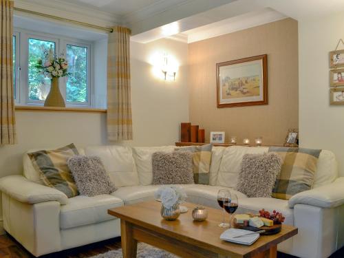 a living room with a white couch and a table at The Coach House in Keswick