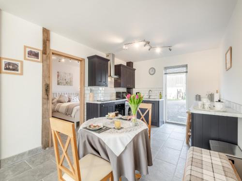 a kitchen and dining room with a table in a room at Pightle Cottage in Poringland