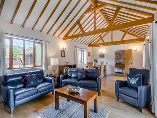 a living room with two blue couches and a table at Beech Barns - Czu in Neatishead