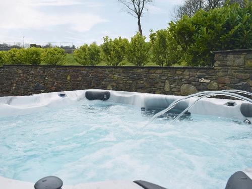a hot tub with a water fountain at The Stable - Om4 in Mydroilin