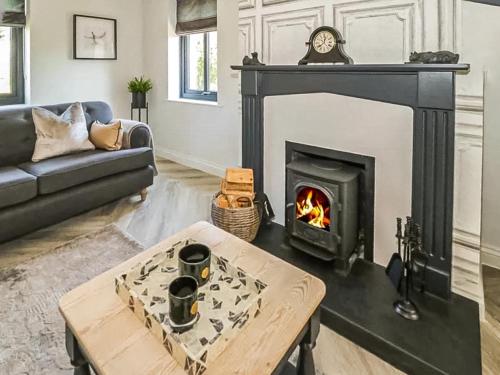 a living room with a fireplace and a coffee table at Garth End in Appleby