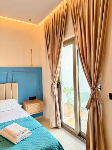 a bedroom with a bed and a large window at Rida Village Hotel Ksamil Island in Ksamil