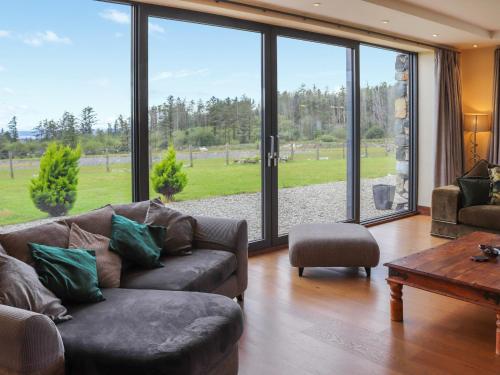 a living room with a couch and a large window at Snowdon Summit View in Llanllyfni