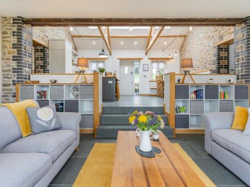 a living room with two couches and a table at Cwtch Ty Gwyn in Llandeilo