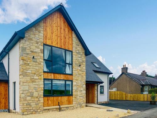 a stone house with a wooden facade at Hillside House in Berwick-Upon-Tweed