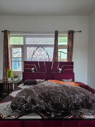 a bedroom with a large bed with a black comforter at Payer Resort in Pharkian