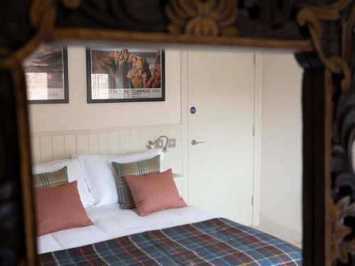 a bedroom with a bed with white sheets and pillows at Tree House - Uk7556 in Inverness