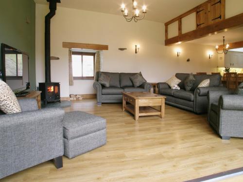 a living room with couches and a fire place at Bram Crag Barn in Legburthwaite
