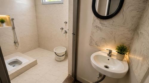 a bathroom with a sink and a toilet and a mirror at Residence Inn in Patna