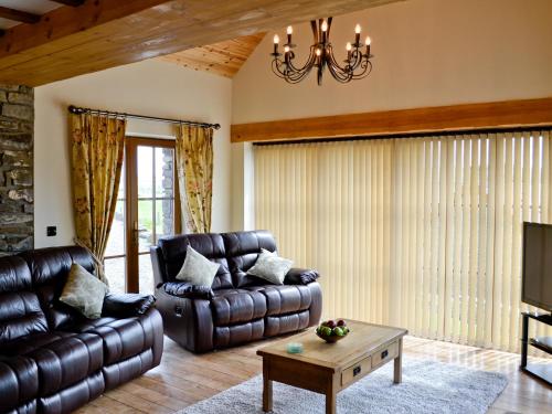 a living room with a leather couch and a table at The Mill - Om3 in Mydroilin