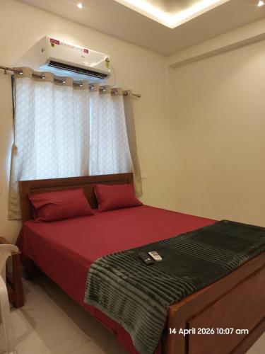 a bedroom with a bed with red pillows and a heater at Vishal Lodge in Yermala