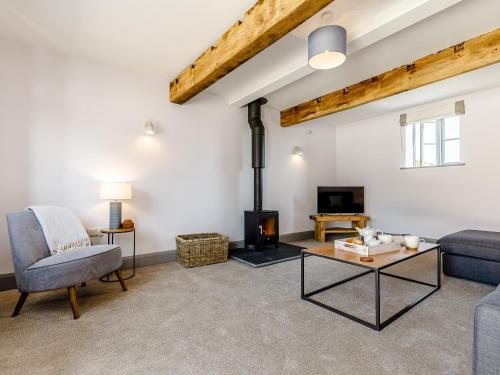 a living room with a couch and a fireplace at The Hayloft - Uk34565 in Whitchurch