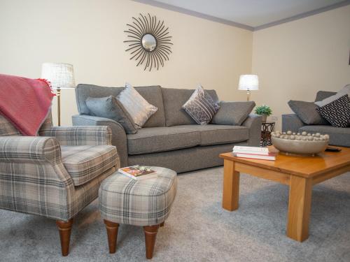 a living room with a couch and a table at Sycamore Cottage-Uk2785 in Penmaen-mawr