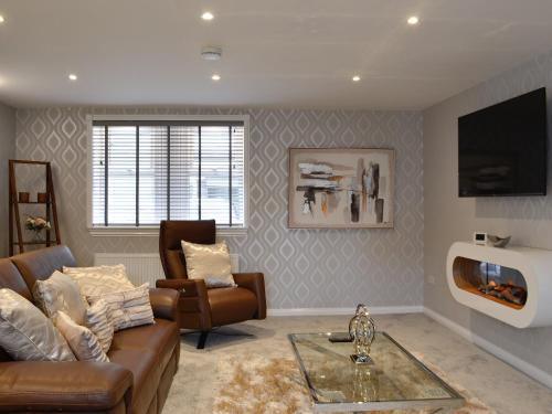 a living room with a couch and a tv at Apple Tree House in Dalry