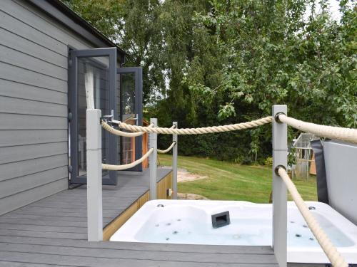a jacuzzi tub on the deck of a house at Ponsford Ponds Jacks Shepherd Hut - Bcponhut in Cullompton