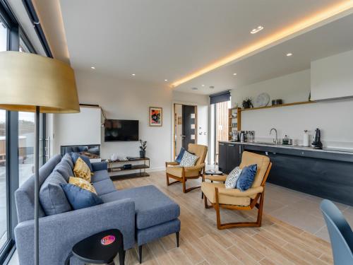 a living room with a blue couch and chairs at Buttercup Lodge - Uk36655 in Boothby Pagnell