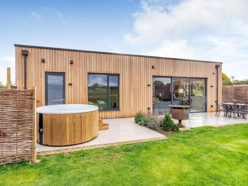 a wooden house with a patio and grass at Buttercup Lodge - Uk36655 in Boothby Pagnell