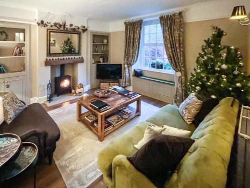 a living room with a christmas tree and a couch at Honey Cottage in Gargrave
