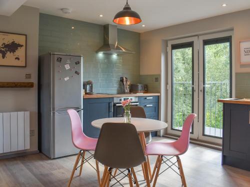 a kitchen with a table and chairs and a refrigerator at Willows View in Etchingham