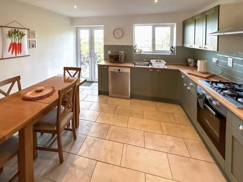 a kitchen with a table and a dining room at No 3 Rabbit Warren-Uk44299 in Lenwade