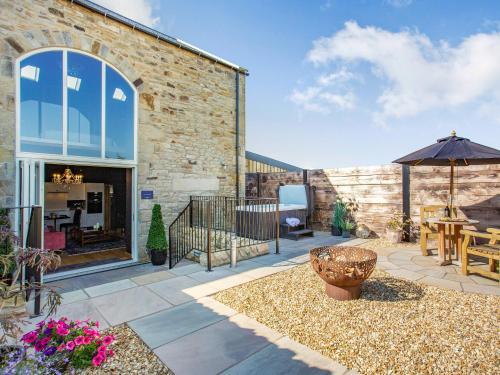 a patio with a table and an umbrella at The Richmond - Uk40459 in Newsham