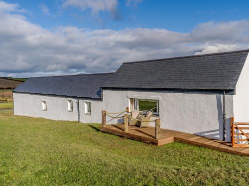 a large white building with a porch and a deck at The Stables - Uk32514 in Marloes