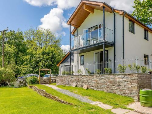 a house with a balcony on top of a stone wall at Barn Owls Rest in Clyro