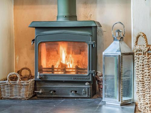 a stove with a fire in a room at Horseshoes House in Watton