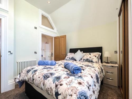 a bedroom with a bed with blue pillows on it at Old School Mews Too in Shanklin