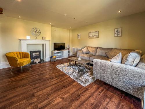 a living room with a couch and a fireplace at Old School Mews Too in Shanklin