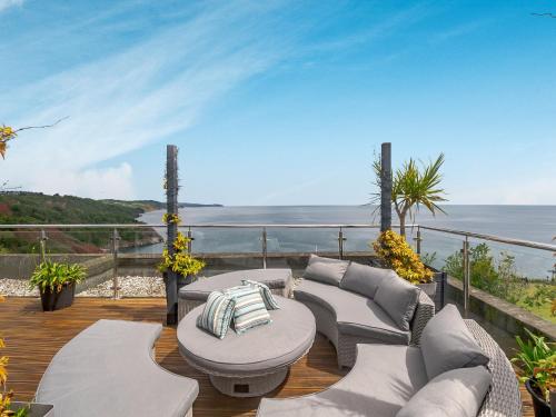 a patio with a table and chairs and the ocean at Babbacombe House in Torquay