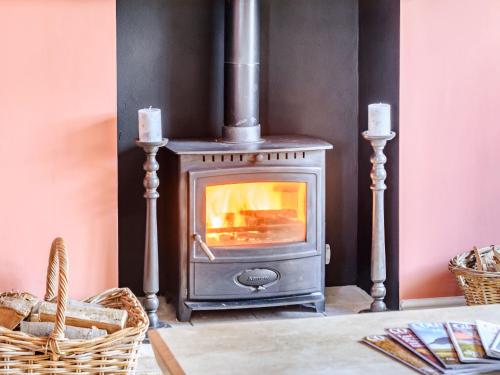 a wood stove in a room with a table at Limber Wold House in Great Limber