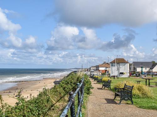 a row of benches on a path near the beach at The Old Barn in Mundesley