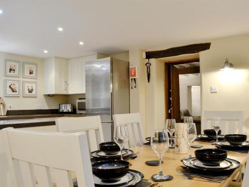 a kitchen with a table with plates and wine glasses at Clawdd Gwyn in Llanrwst