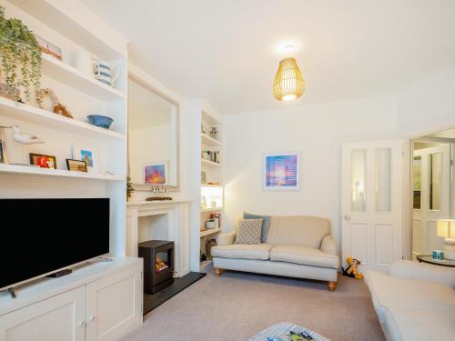 a living room with a tv and a couch at Isfryn in Llanbedr