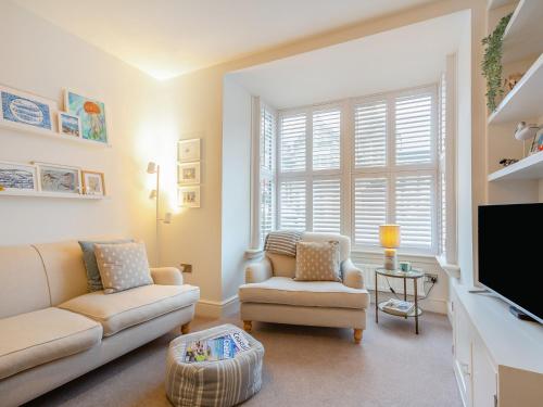 a living room with two couches and a tv at Isfryn in Llanbedr