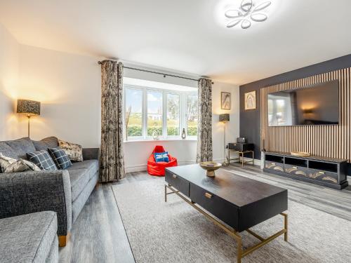a living room with a couch and a table at Cowslip Cottage - Uk47072 in Maltby le Marsh