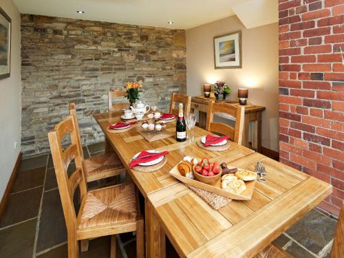 a wooden table with bread and a bottle of wine at Birch Cottage - Uk4185 in Hazlehead Bridge