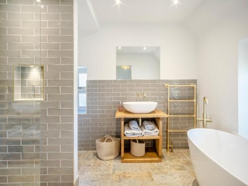 a bathroom with a sink and a bath tub at Sandstones in Niton