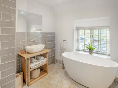 a bathroom with a white tub and a sink at Sandstones in Niton