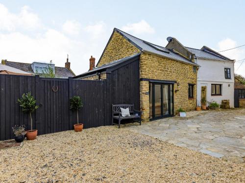 an extension to a brick house with a black fence at Coach House - Uk32202 in Burton Bradstock